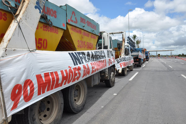 Empresas levaram caminhões e faixas para a porta de acesso ao aeroporto para cobrar dívida. (Foto: Emanuel Amaral)